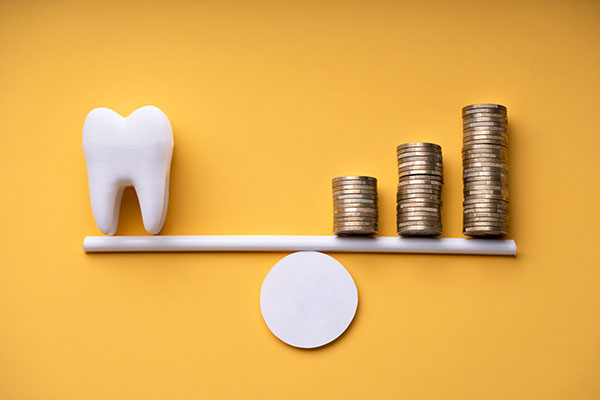 Graphic showing a tooth model being balanced by coins
