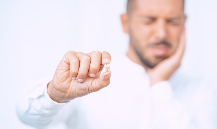 Patient holding an extracted wisdom tooth
