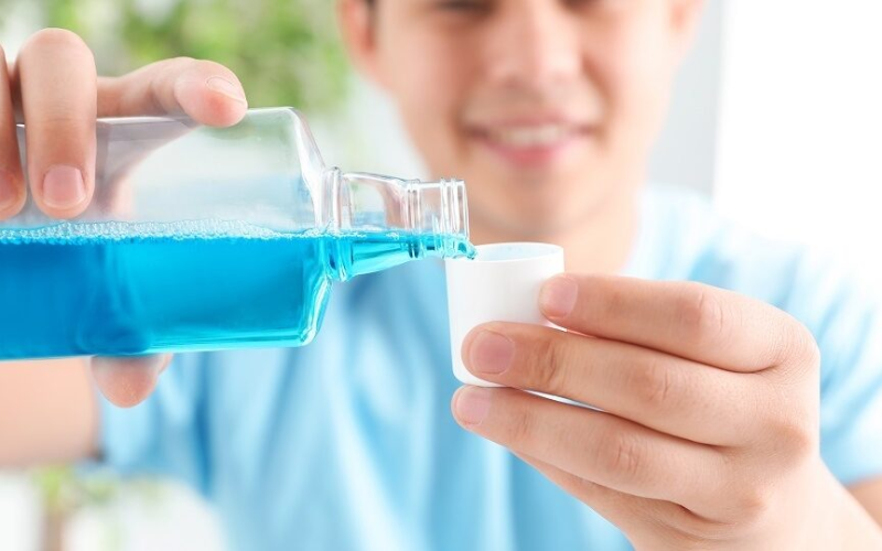 Patient using mouthwash as part of an oral hygiene routine