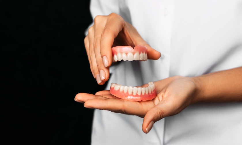 Hands demonstrating proper denture cleaning techniques