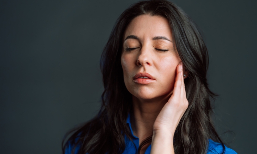 Woman holding her cheek due to dental discomfort