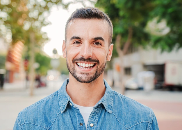 Man smiling confidently outdoors