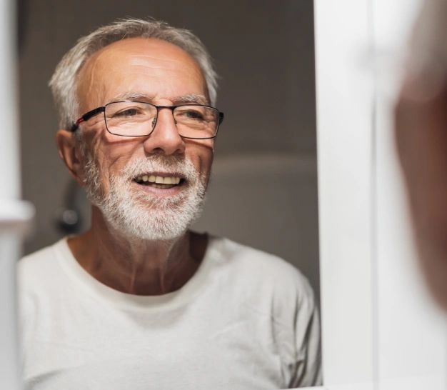 Senior man smiling while looking at mirror