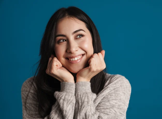 Smiling young woman resting chin on hands
