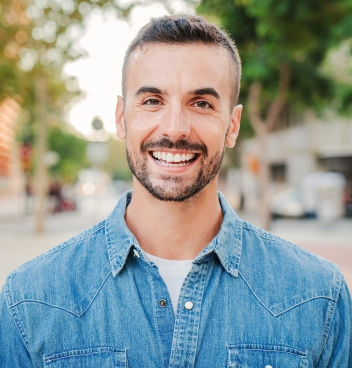 Man smiling confidently outdoors