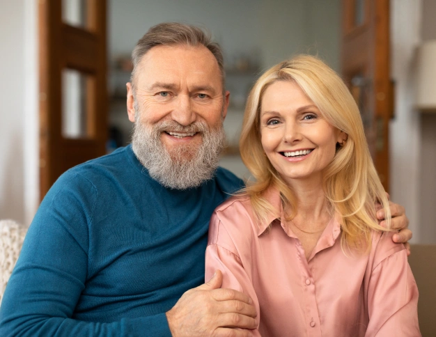 Elder couple posing for a photo indoors