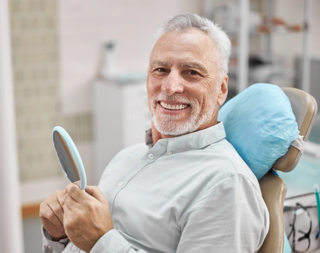 Older woman sitting on a dental chair and smiling