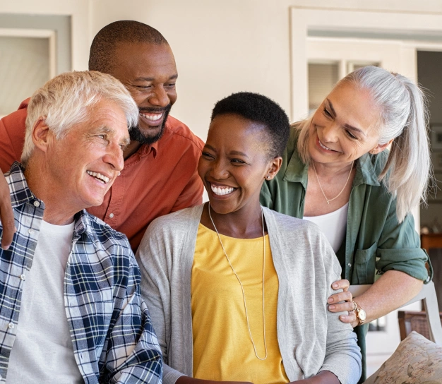 Four adults smiling inside a dental office