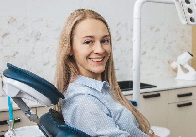 Young woman sitting on a dental chair and smiling