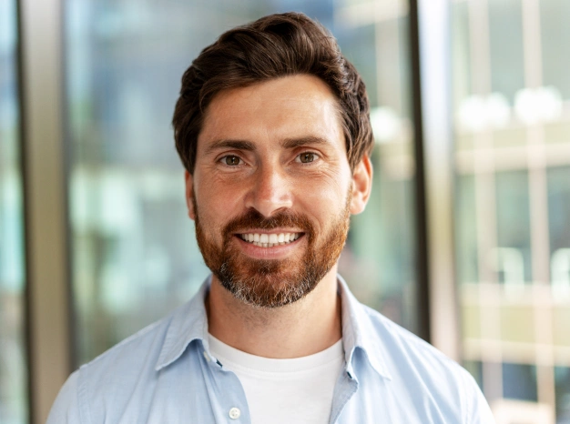 Man smiling inside a dental office