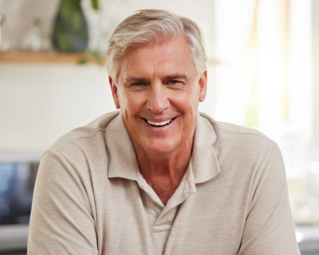 Elderly man sitting in a dental office and smiling